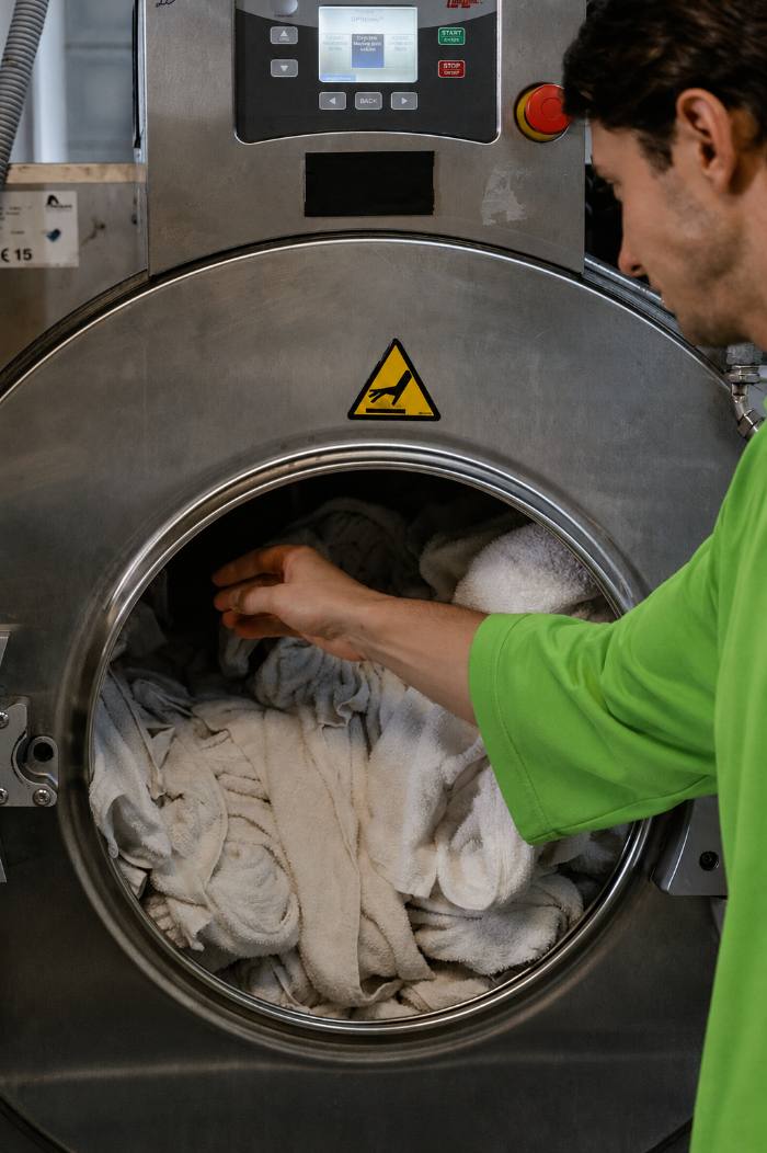 Loading towels into a commercial washing machine